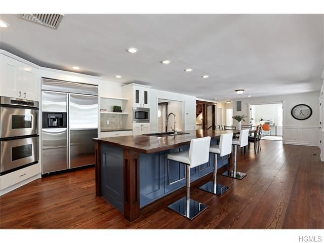 White kitchen with navy blue island and wine storage built by Division Seven Millwork