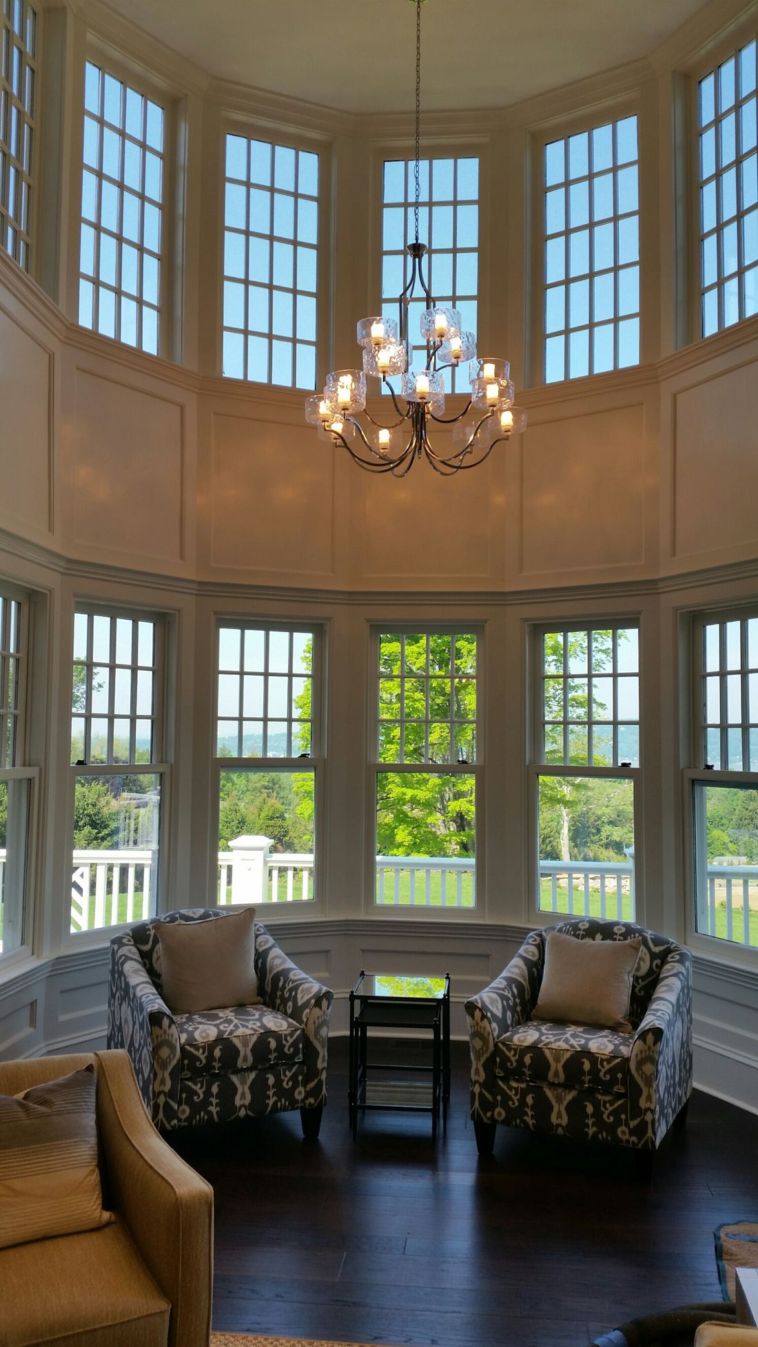 Two-story turret window wall with wainscoting and window seat trim by Division Seven Millwork