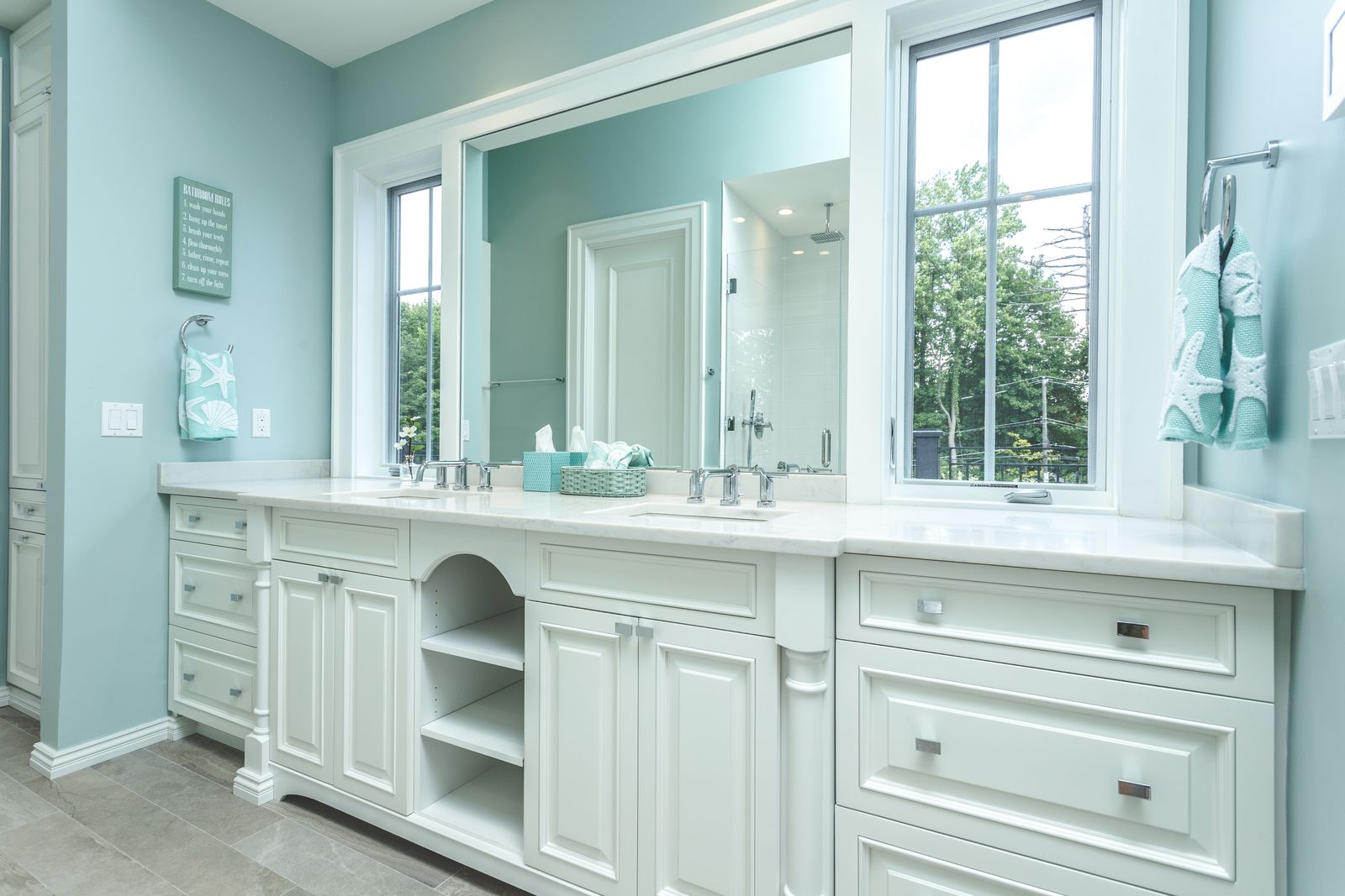 Long white double vanity with open shelving built and installed by Division Seven Millwork